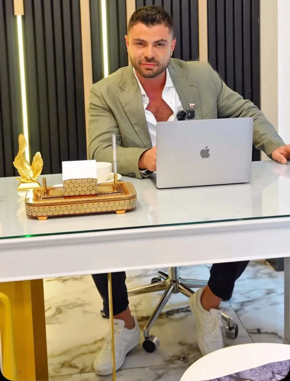 Dr. Fırat Küçüktürkmen, açık yeşil ceketle muayenehanesinde